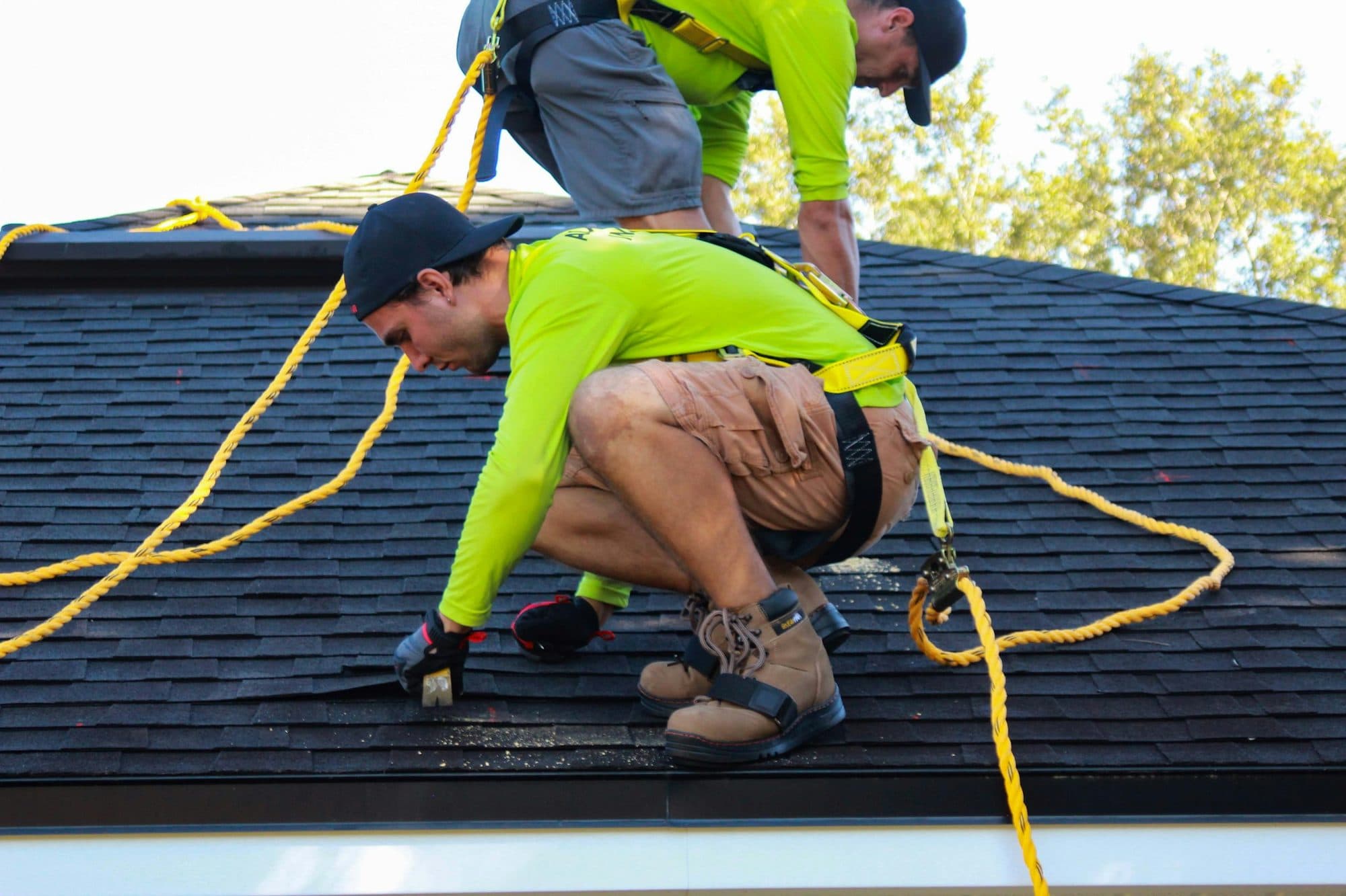 Two roofers working together on a residential roof